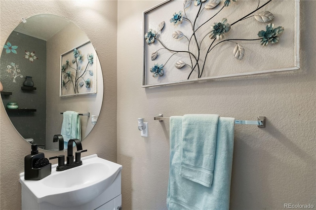 bathroom with a textured wall and vanity