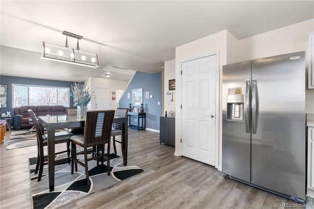 dining area with baseboards and wood finished floors