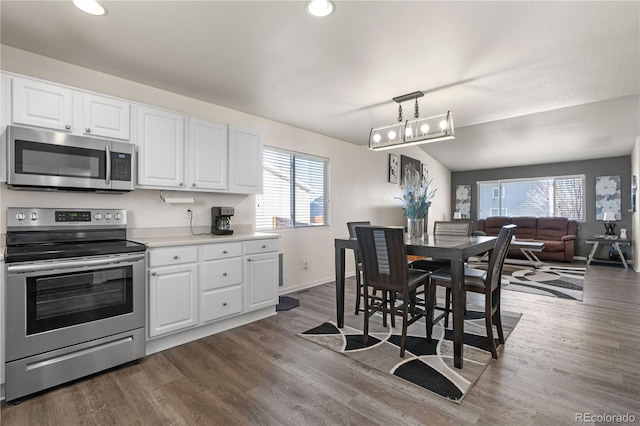 kitchen with dark wood-style floors, white cabinetry, appliances with stainless steel finishes, and light countertops