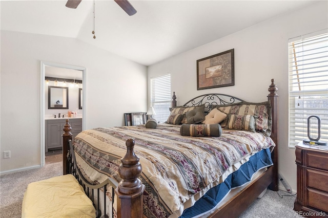 bedroom featuring light carpet, vaulted ceiling, a ceiling fan, and ensuite bathroom