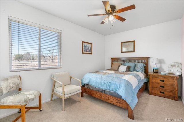 bedroom with light carpet, ceiling fan, and baseboards