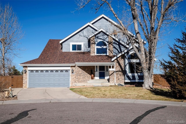 view of front of house with fence, a garage, stone siding, driveway, and a front lawn