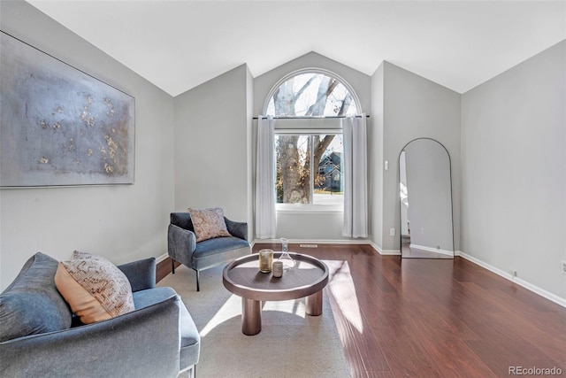 sitting room with lofted ceiling, baseboards, and wood finished floors