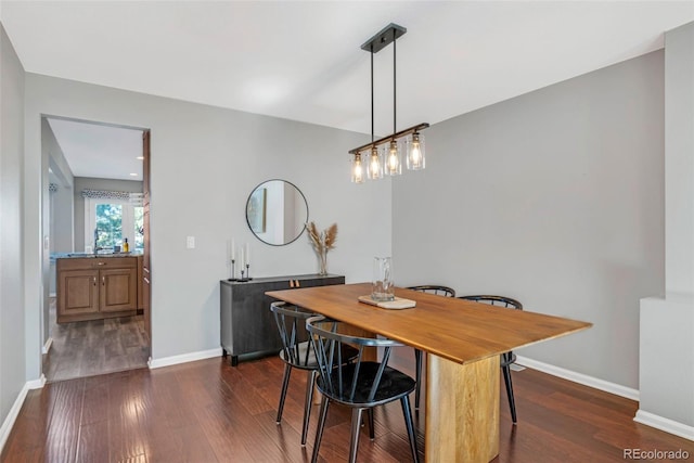 dining area featuring dark wood-style floors and baseboards