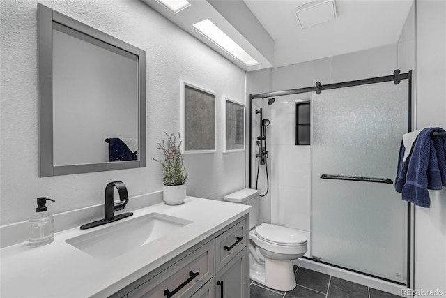 bathroom with a textured wall, toilet, tile patterned floors, vanity, and a shower stall