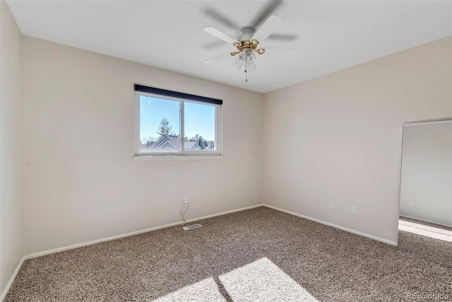 carpeted spare room featuring ceiling fan, visible vents, and baseboards