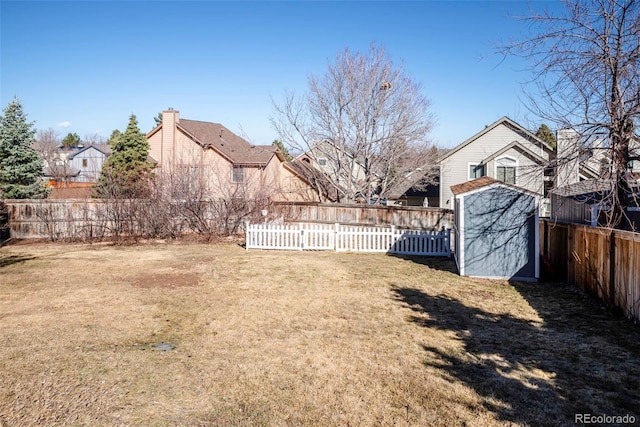 view of yard featuring an outbuilding, a fenced backyard, and a residential view