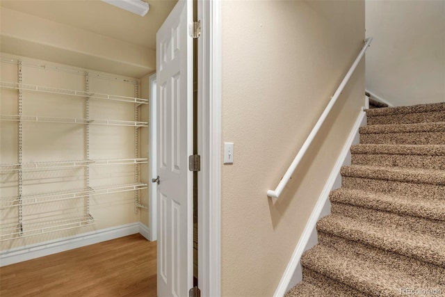 stairway with baseboards and wood finished floors