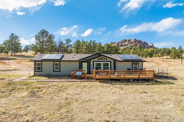 464 Hackamore Dr, Florissant, CO 80816 - back of house featuring a lawn, solar panels, and a deck