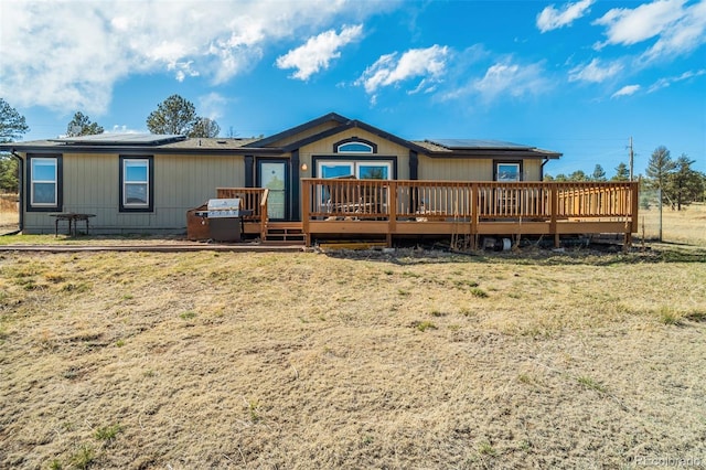 464 Hackamore Dr, Florissant, CO 80816 - back of house with roof mounted solar panels, a yard, and a deck