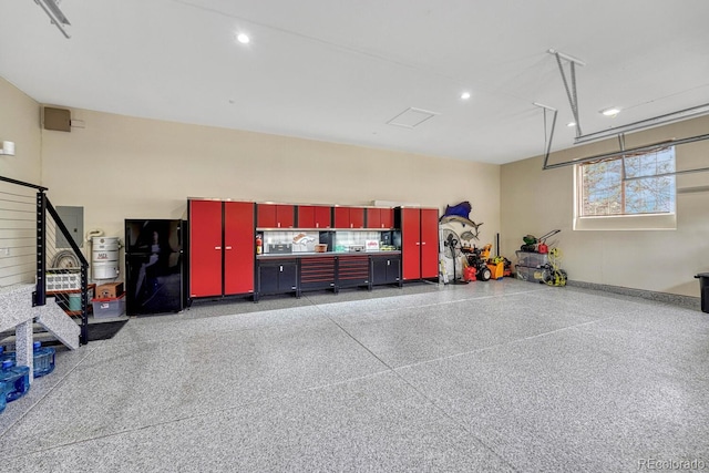 garage with freestanding refrigerator and recessed lighting