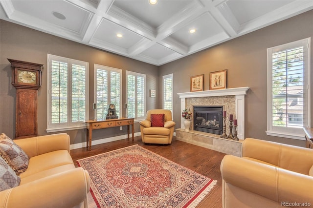 living area featuring a tiled fireplace, beamed ceiling, coffered ceiling, and wood finished floors