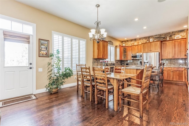 dining area with recessed lighting, baseboards, dark wood-type flooring, and a notable chandelier