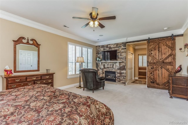 bedroom with carpet, visible vents, a barn door, a fireplace, and crown molding