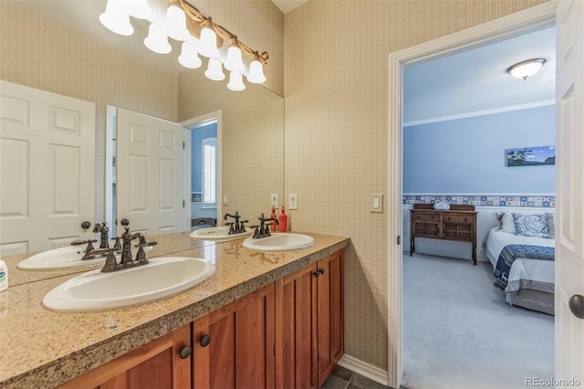 ensuite bathroom featuring double vanity, wallpapered walls, and a sink