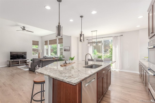 16694 Miners Way, Broomfield, CO 80023 - kitchen with stainless steel appliances, light wood-type flooring, recessed lighting, a kitchen island with sink, and a ceiling fan