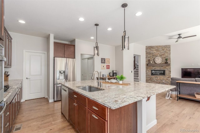 16694 Miners Way, Broomfield, CO 80023 - kitchen with open floor plan, light wood-type flooring, light stone countertops, appliances with stainless steel finishes, and recessed lighting