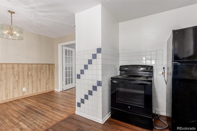 770 Havana St, Aurora, CO 80010 - kitchen with black appliances, wood finished floors, a wainscoted wall, a chandelier, and baseboards