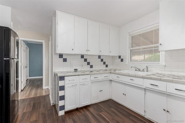 770 Havana St, Aurora, CO 80010 - kitchen featuring freestanding refrigerator, dark wood-style floors, tile counters, and white cabinetry