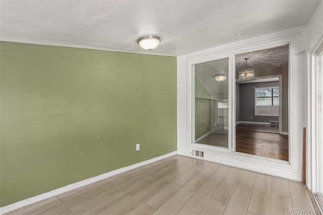 770 Havana St, Aurora, CO 80010 - spare room featuring baseboards, wood finished floors, and a chandelier