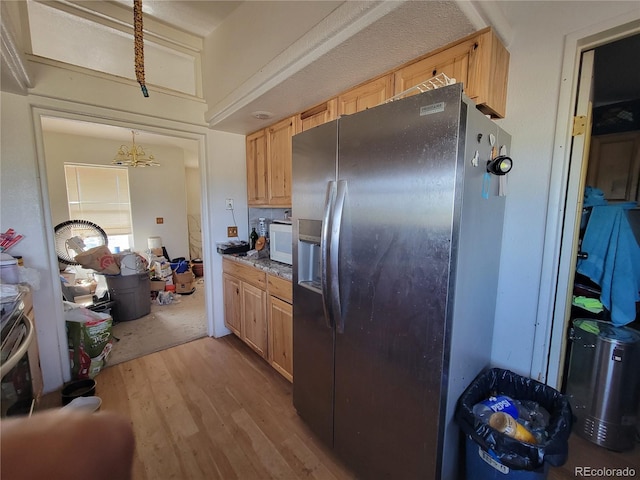 71777 E County Road 10, Byers, CO 80103 - kitchen with stainless steel fridge with ice dispenser, light wood finished floors, a chandelier, and light brown cabinetry