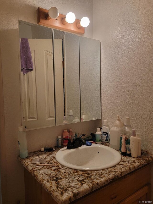71777 E County Road 10, Byers, CO 80103 - bathroom with vanity and a textured wall