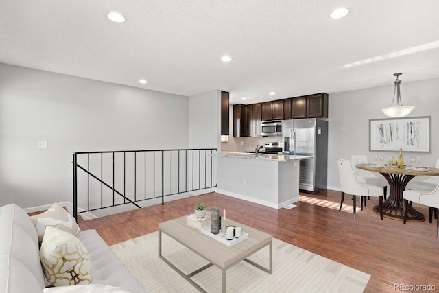 living room featuring dark hardwood / wood-style flooring, a textured ceiling, and sink