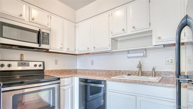 kitchen featuring white cabinetry, appliances with stainless steel finishes, light countertops, and a sink