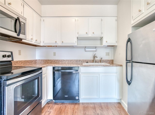 kitchen featuring white cabinets, appliances with stainless steel finishes, light countertops, open shelves, and a sink