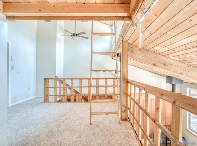 interior space with carpet, wooden ceiling, ceiling fan, and beam ceiling