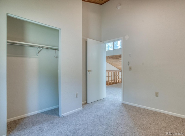 unfurnished bedroom featuring a closet, baseboards, and carpet flooring