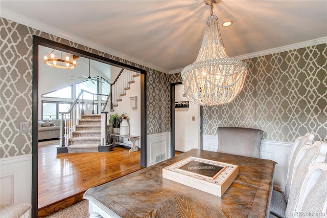 dining room with crown molding, ceiling fan with notable chandelier, and hardwood / wood-style flooring