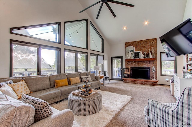 carpeted living room featuring a fireplace, high vaulted ceiling, and ceiling fan