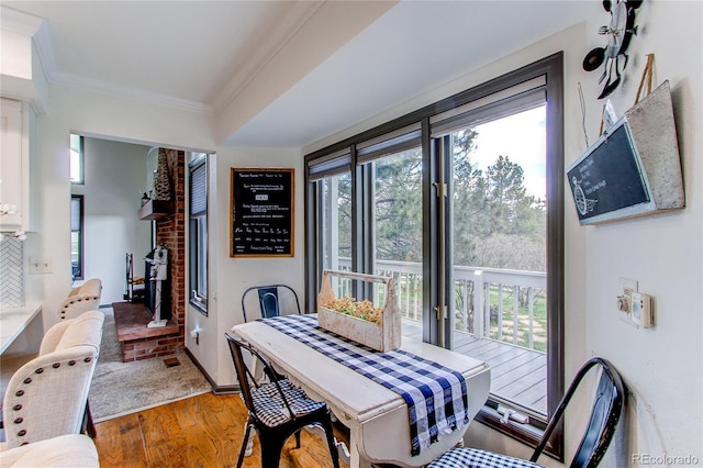 dining area featuring hardwood / wood-style flooring, ornamental molding, and a healthy amount of sunlight