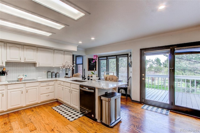 kitchen featuring white cabinetry, kitchen peninsula, sink, and black appliances