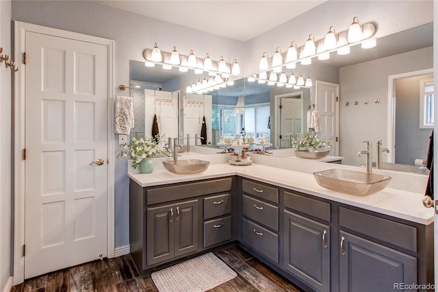 bathroom with hardwood / wood-style flooring, vanity, and a shower