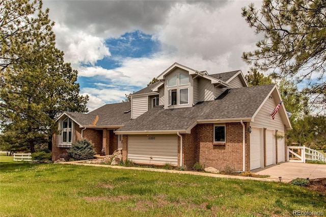 view of front of home with brick siding, fence, driveway, roof with shingles, and a front yard