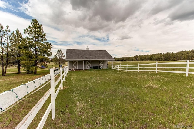 view of yard with an outbuilding and a rural view