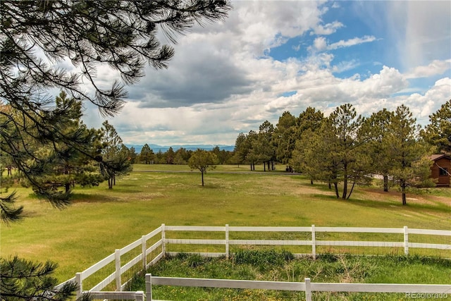 view of yard featuring a rural view and fence