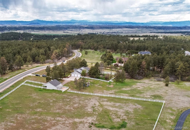 birds eye view of property with a mountain view and a wooded view