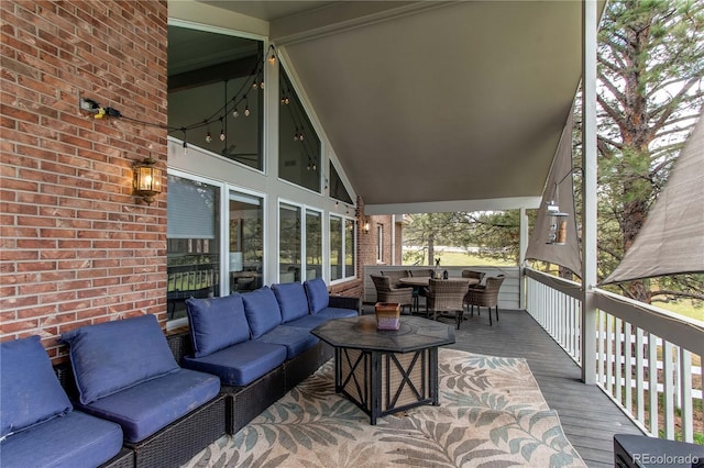 wooden terrace with an outdoor hangout area and outdoor dining area