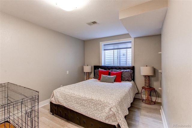 bedroom featuring visible vents, baseboards, and wood finished floors