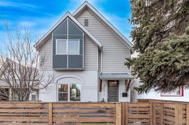 view of front of house featuring a fenced front yard and brick siding