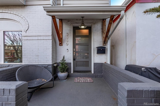 doorway to property featuring brick siding