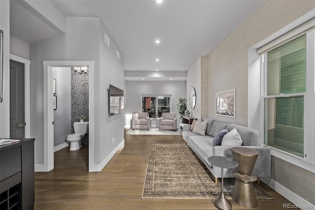 living area with a chandelier, recessed lighting, wood finished floors, and baseboards