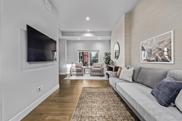 living area with visible vents, baseboards, wood finished floors, and recessed lighting