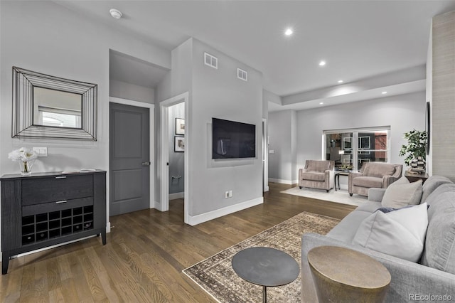 living area with baseboards, wood finished floors, visible vents, and recessed lighting