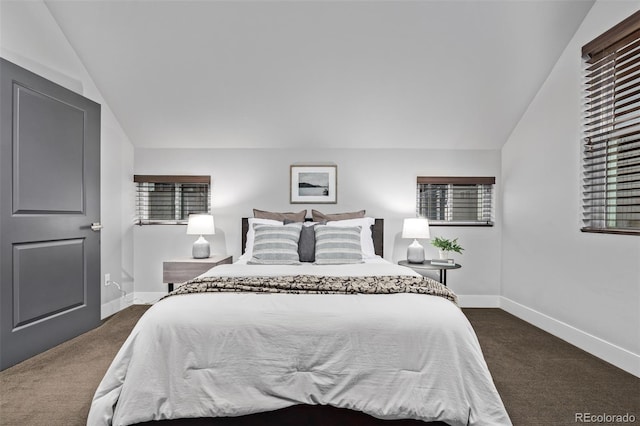 bedroom with lofted ceiling, baseboards, and dark colored carpet