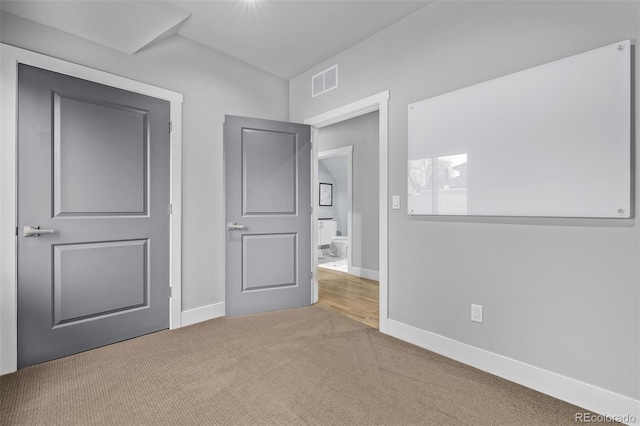 unfurnished bedroom featuring carpet, visible vents, and baseboards