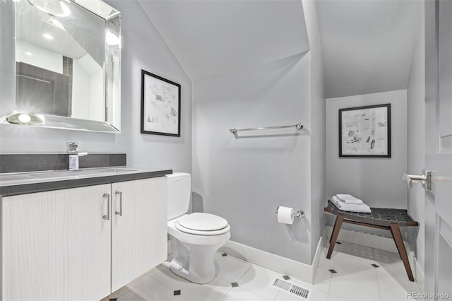 bathroom with lofted ceiling, toilet, visible vents, vanity, and tile patterned floors